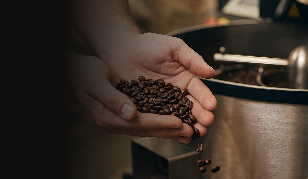Tostador de café artesanal sosteniendo granos