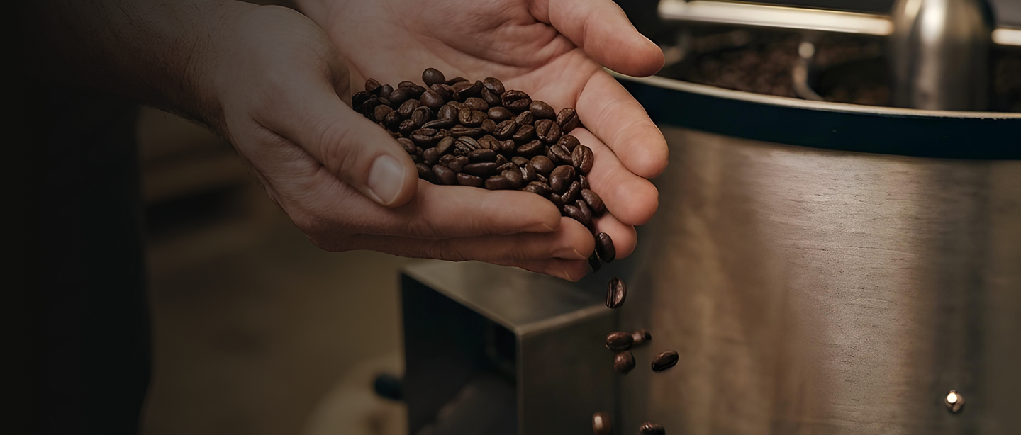 Tostador de café artesanal sosteniendo granos